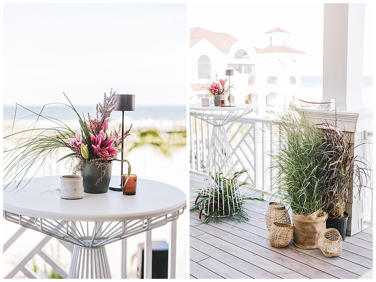 White metal cocktail tables set up on the patio of a beachside house.