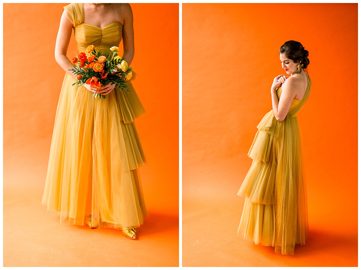 Model in a vintage marigold tulle dress poses in front of a burnt orange backdrop with a sunset-inspired wedding bouquet.