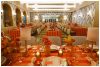Vibrant event setup with orange-striped table linens and lush floral centerpieces, celebrating Verona Sunset for Brides x Minted event, styled by Something Vintage Rentals.