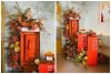 Vintage orange telephone booth with lush floral decor in warm sunset tones, adding a playful touch to the Verona Sunset event decor by Something Vintage Rentals.