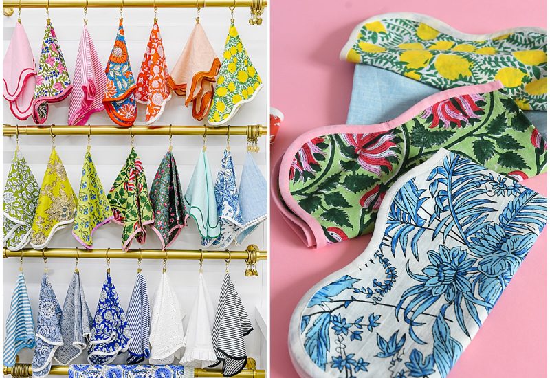 Assorted printed linens in bold floral and striped patterns, styled on brass racks and pink backdrops to highlight the OG linen collection from Something Vintage Rentals, the U.S. East Coast’s best event rental and wedding decor company.